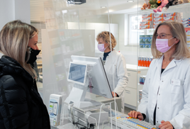 Zwei Mitarbeiter der Paulus Apotheke Saarbrücken, mit Mundschutz, beraten einen Kunden